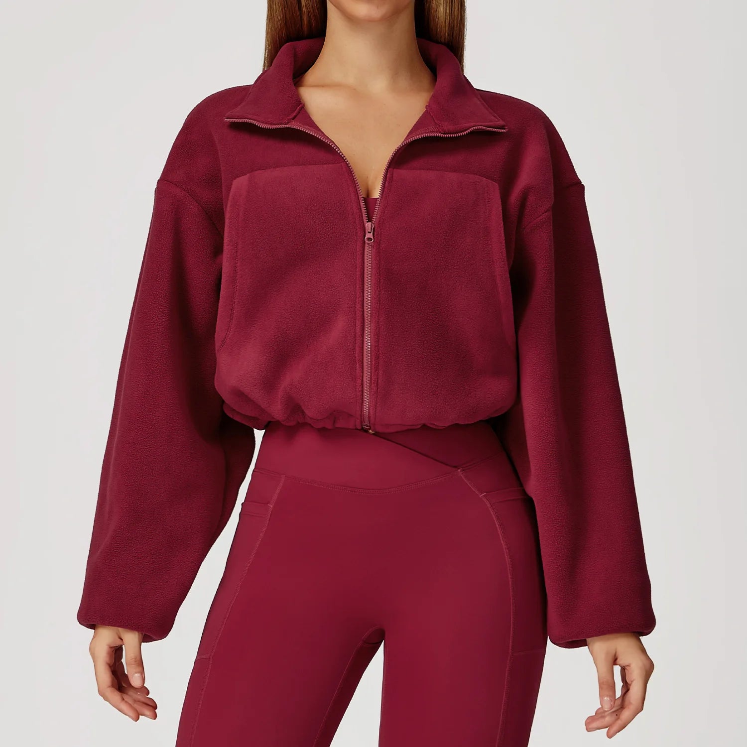 Maroon tracksuit worn by a person on a light gray background