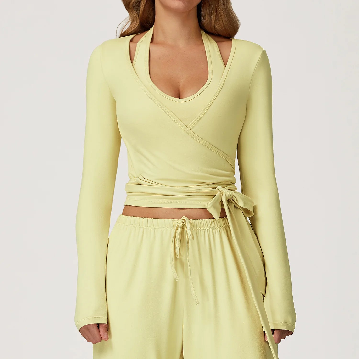 Light yellow long-sleeve ballet wrap top and pants set on a plain background