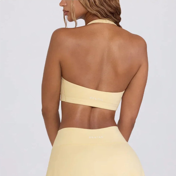 Woman wearing a yellow bikini set on a light gray background