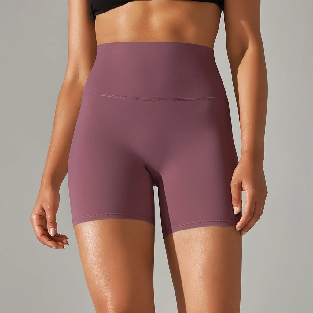 Plum athletic shorts worn by a person on a gray background