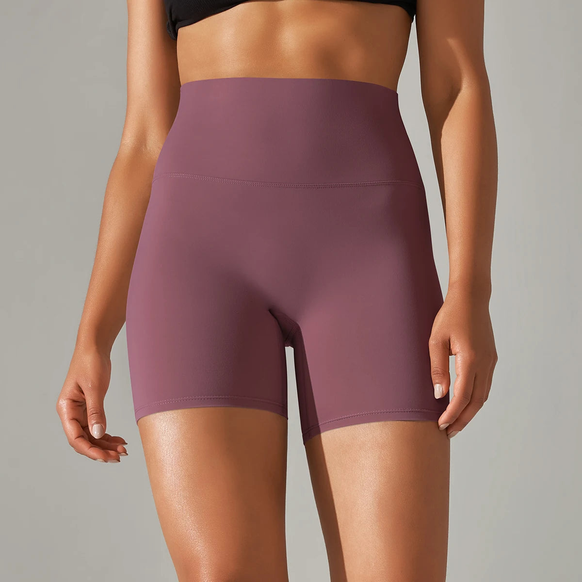 Plum athletic shorts worn by a person on a gray background