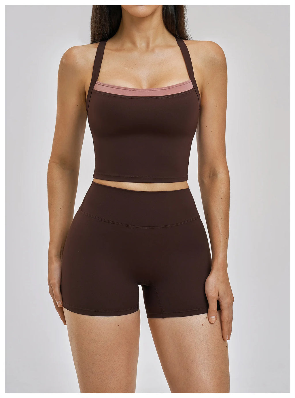 Person wearing a brown sports bra and shorts set on a plain background