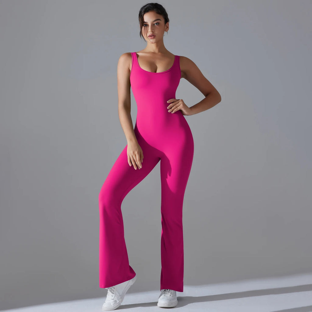 Woman wearing a bright pink jumpsuit against a gray background