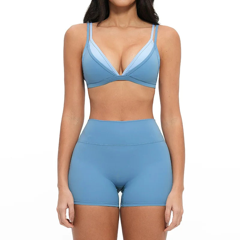 Woman wearing a blue sports bra and shorts set on a white background