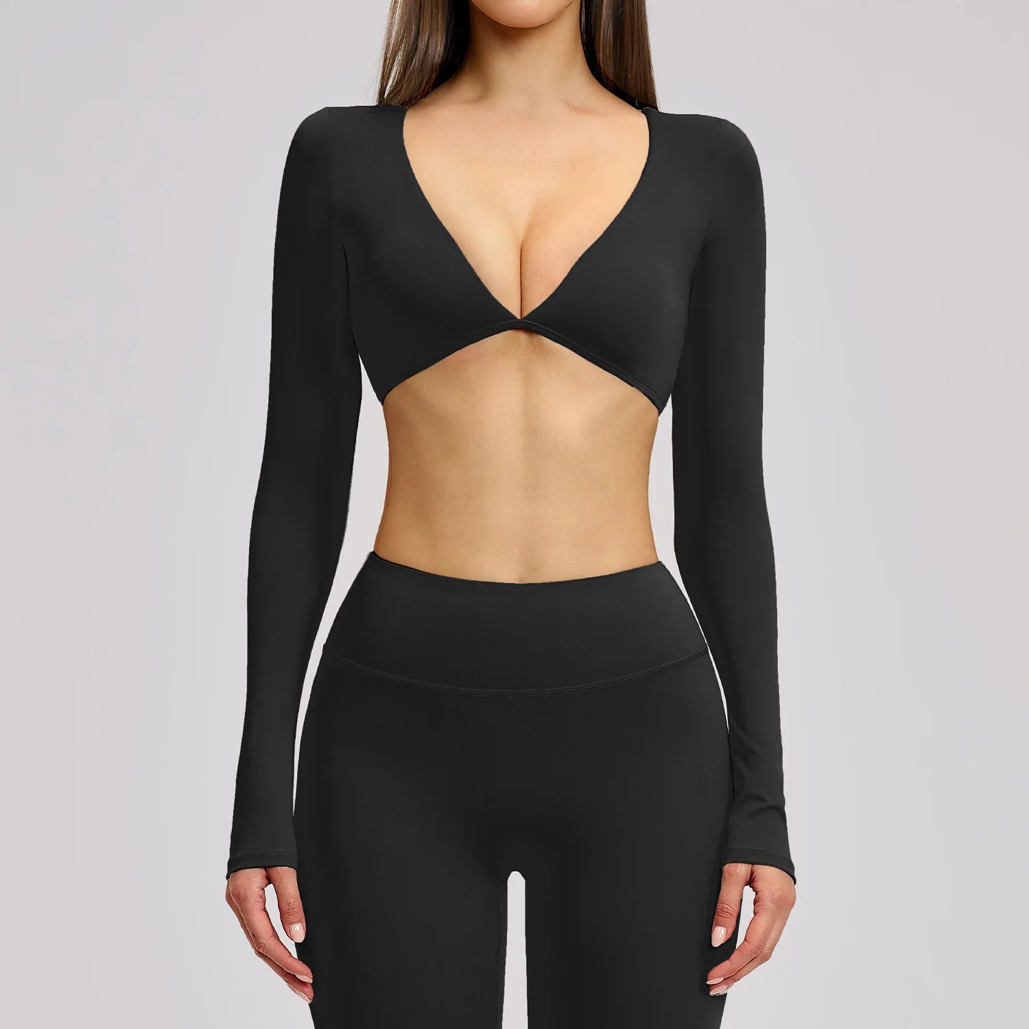 Black long-sleeve top with cut-out design on a gray background