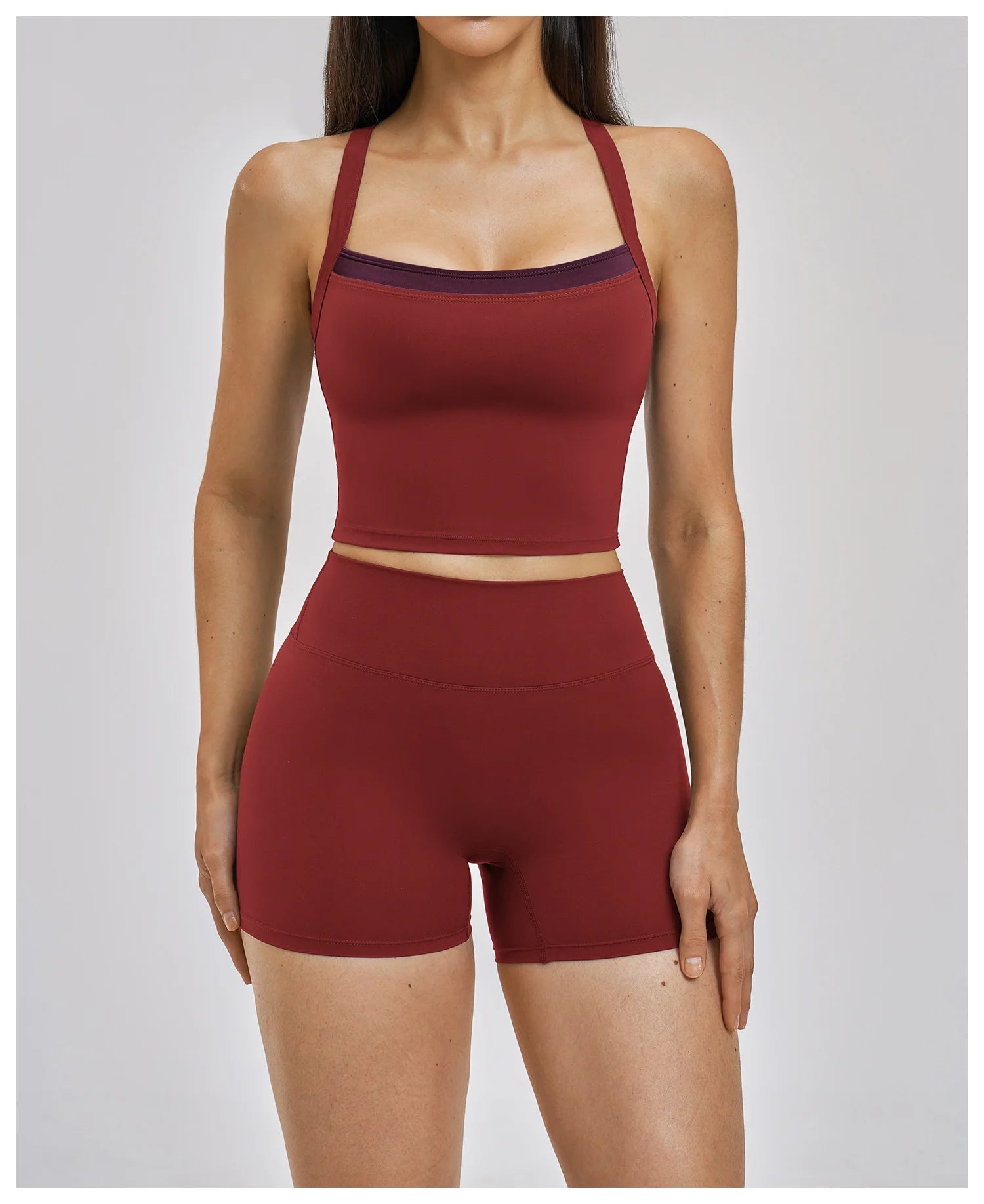 Maroon sports bra and shorts set on a plain background