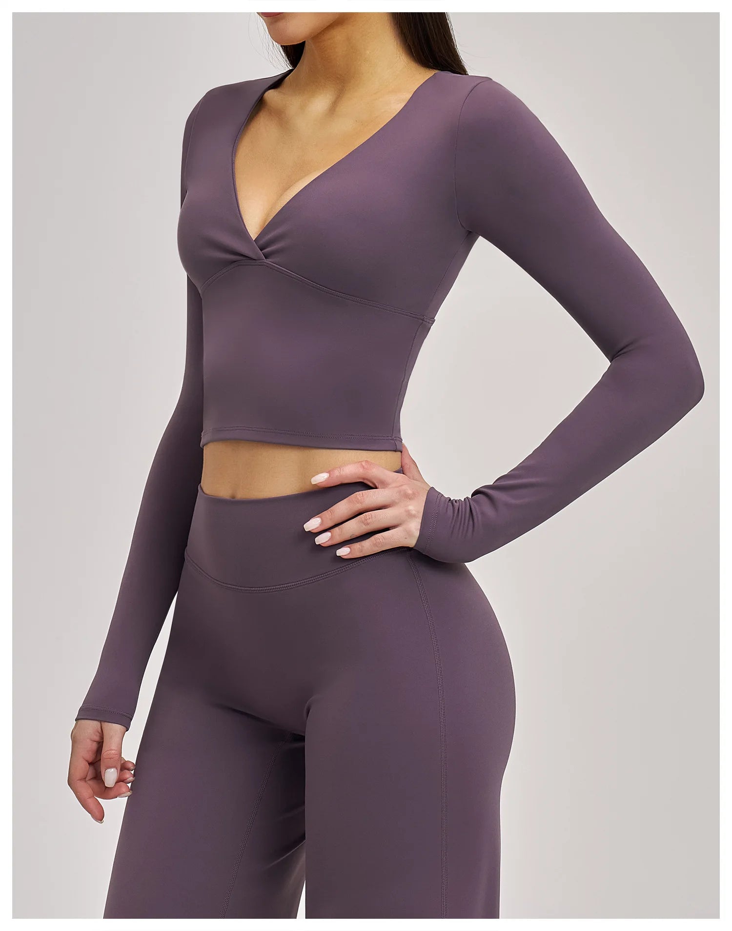 Purple long-sleeve crop top and leggings set on a plain background