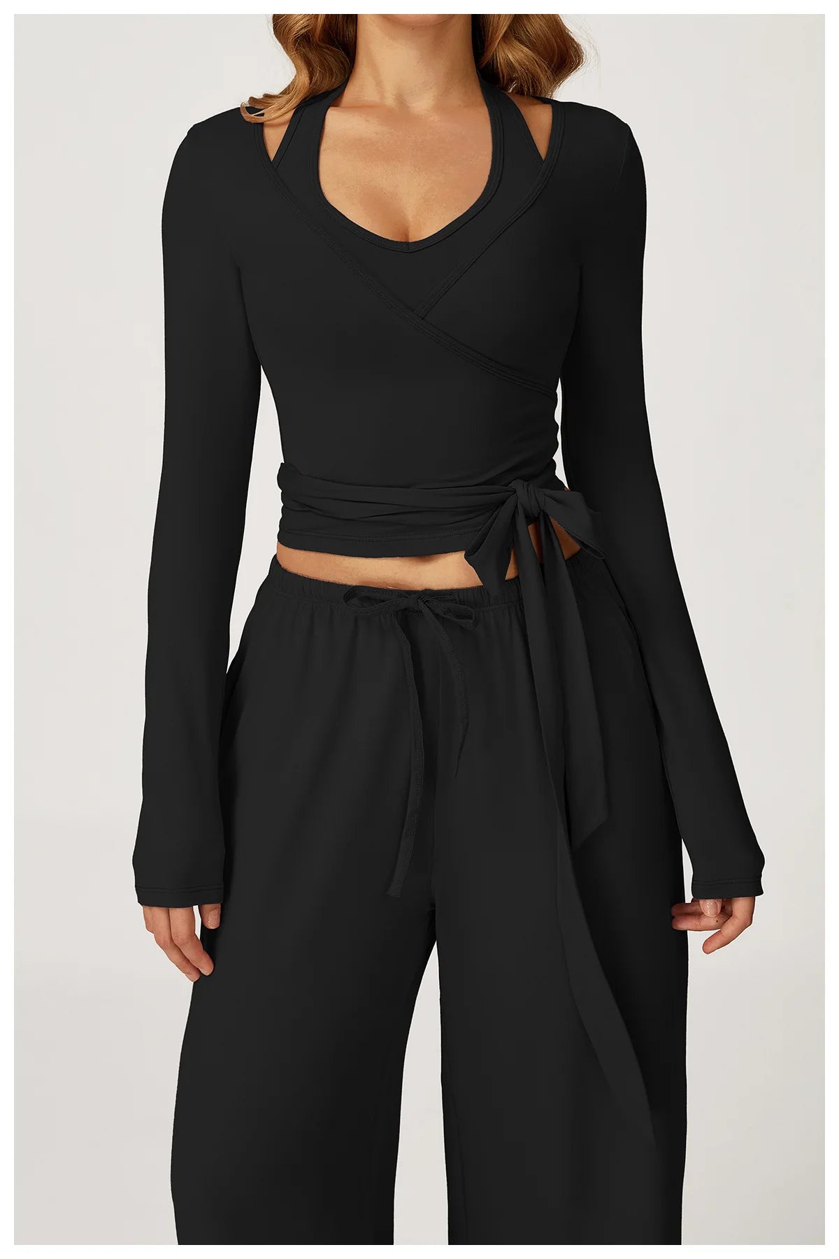 Black long-sleeve ballet wrap top and wide-leg pants set on a white background