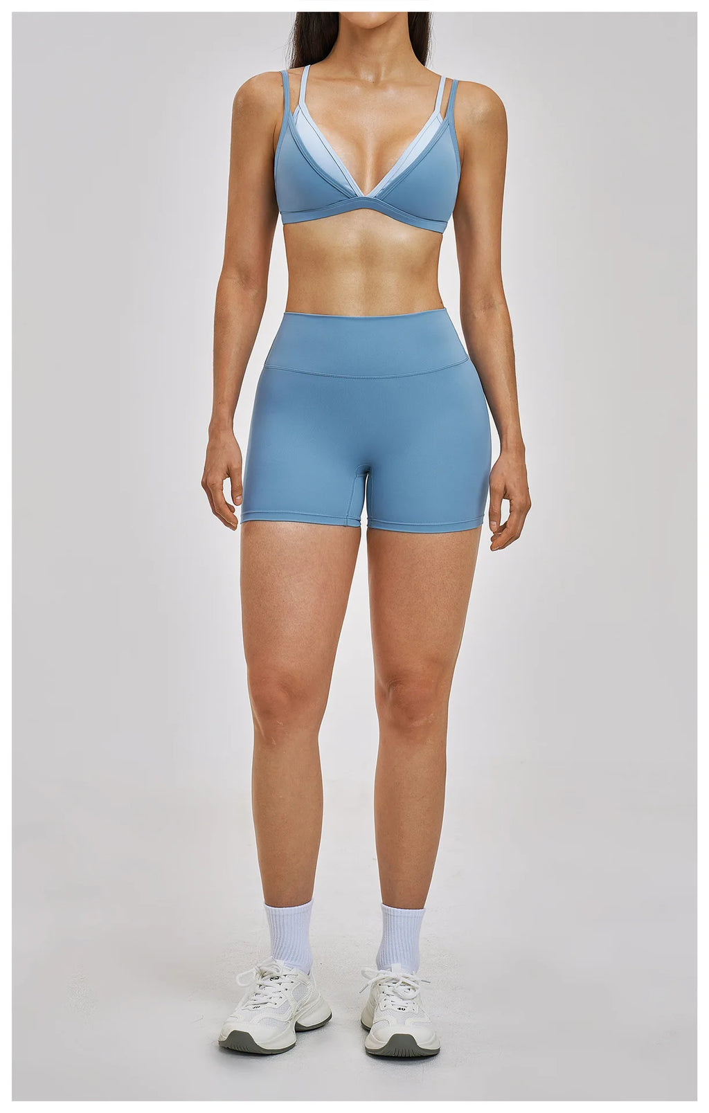 Person wearing a blue athletic outfit on a gray background