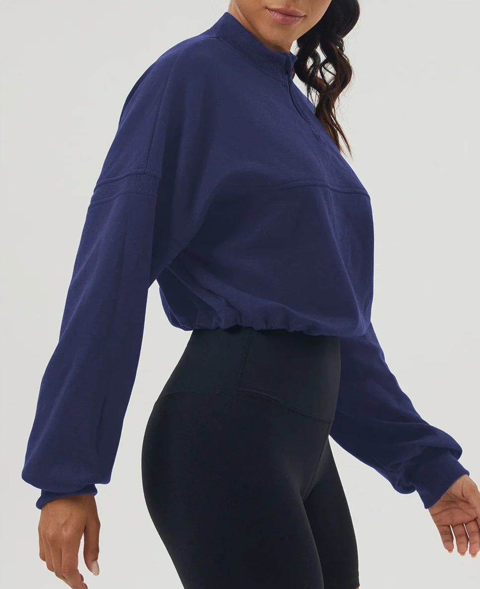 Person wearing a blue sweatshirt and black leggings on a white background