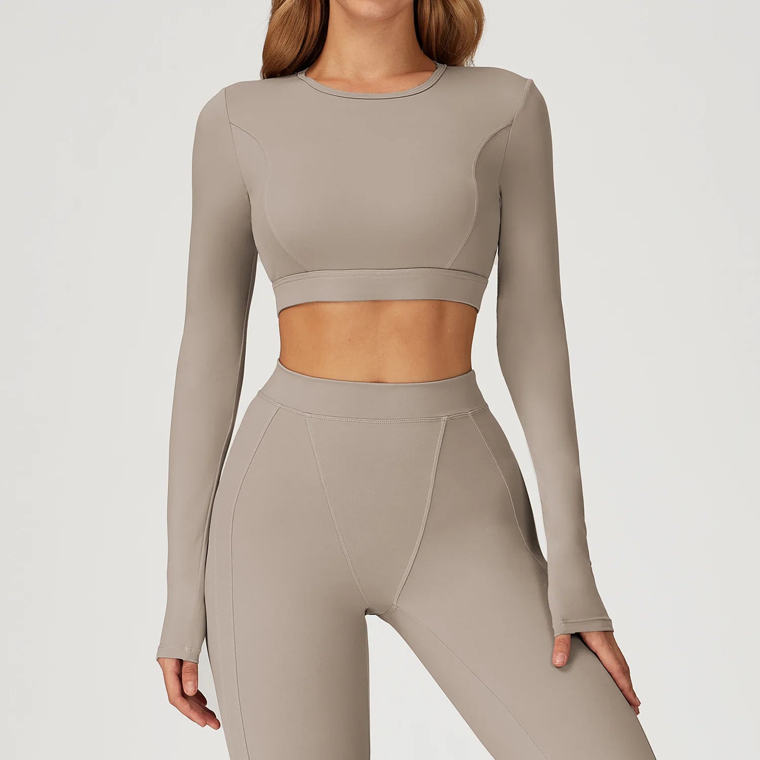 Beige long-sleeve crop top and leggings set on a plain background