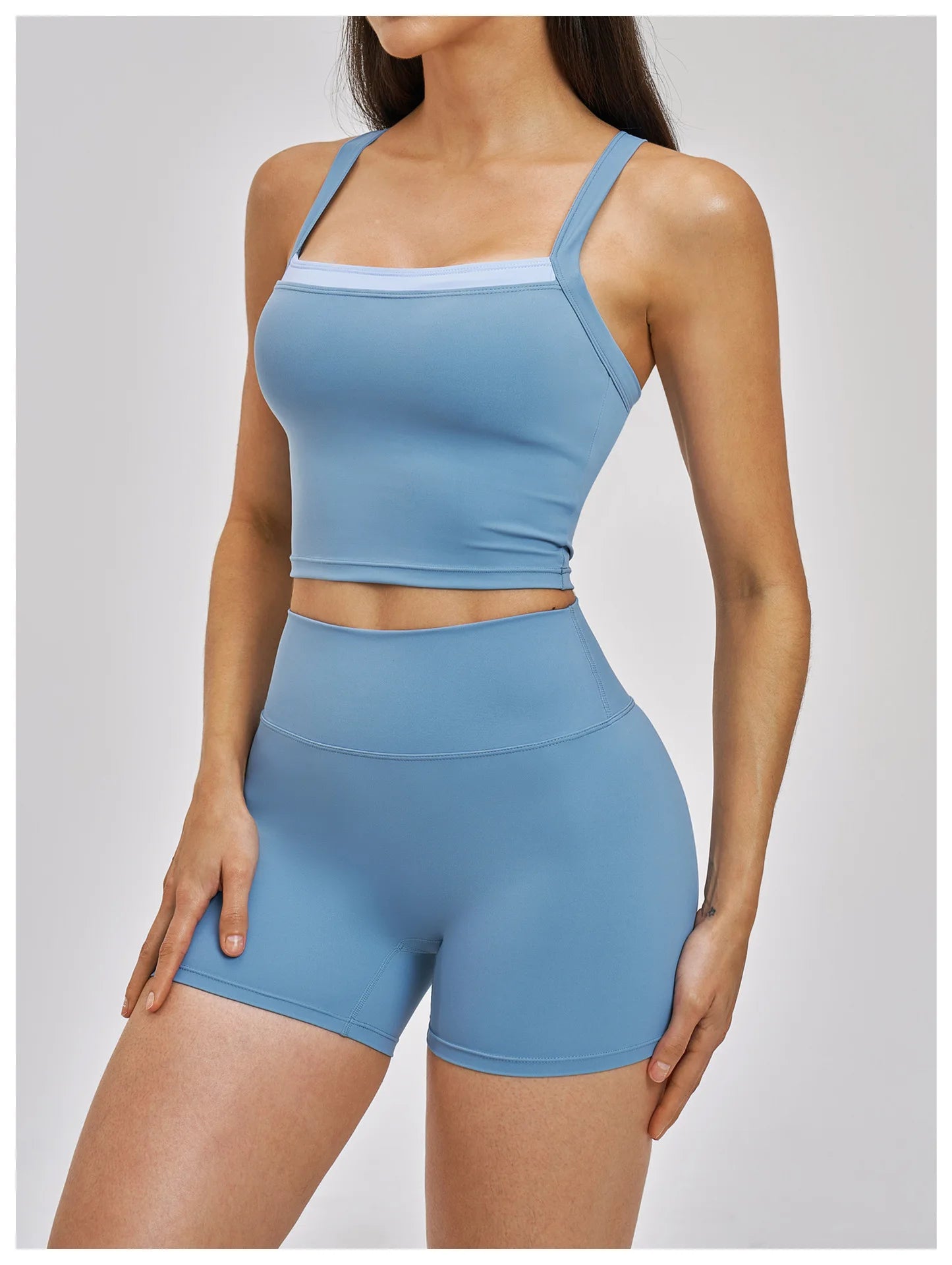 Woman wearing a blue athletic outfit on a plain background