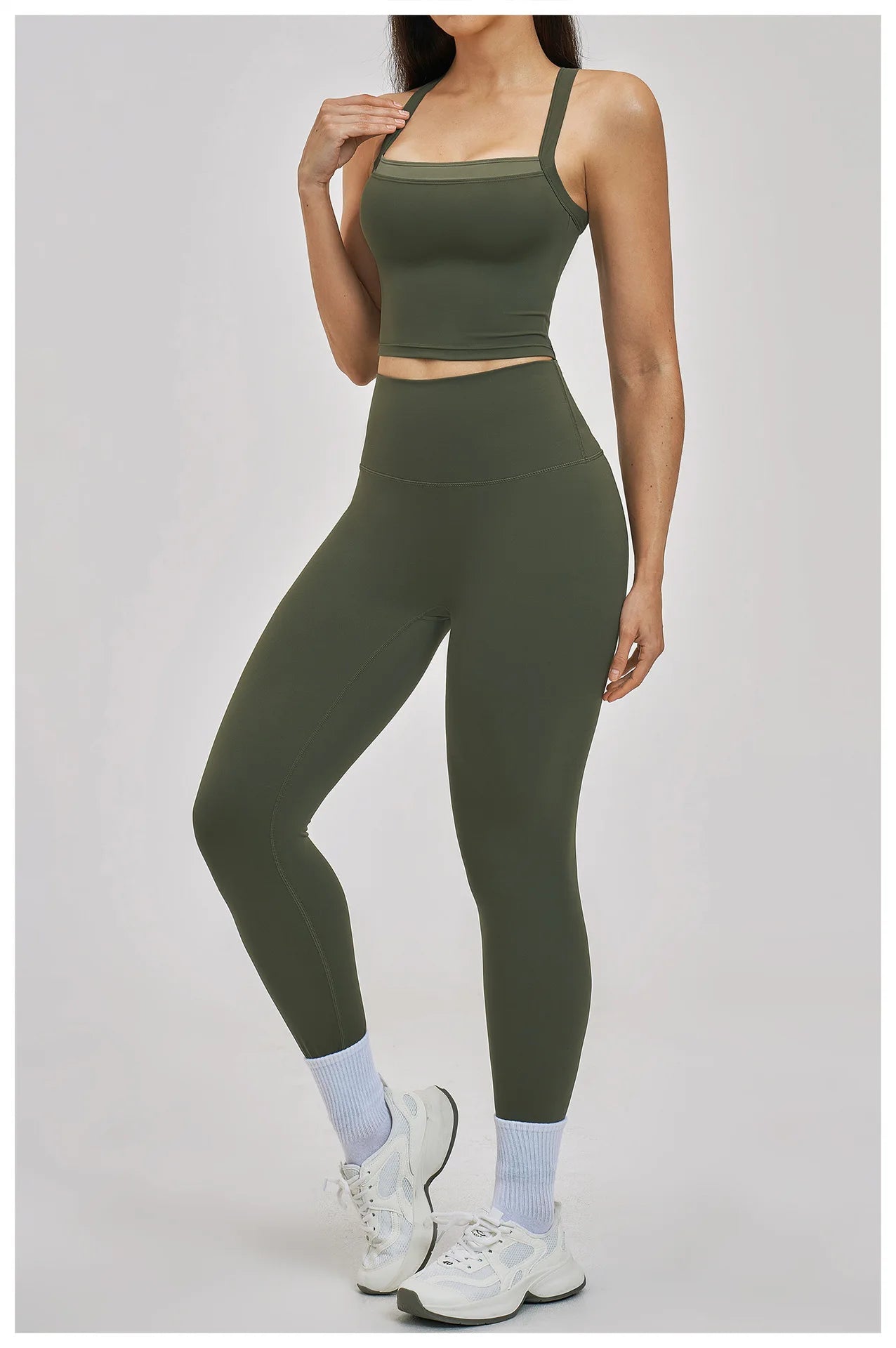 Person wearing an olive green athletic outfit on a light gray background