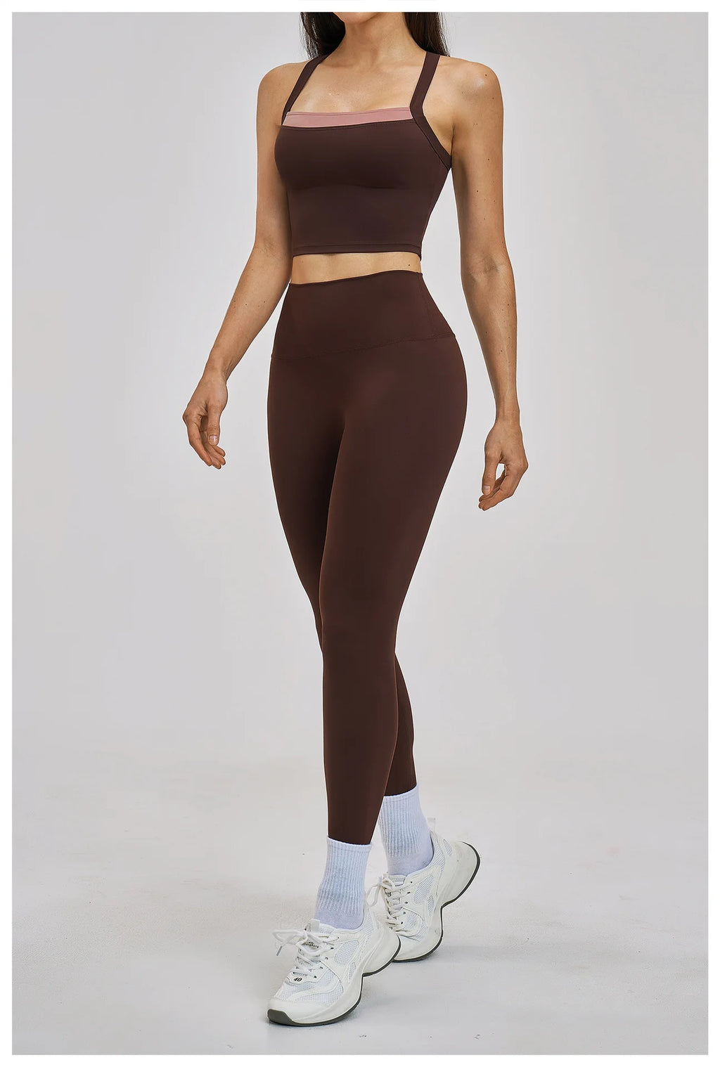Person wearing a brown sports bra and leggings set on a gray background