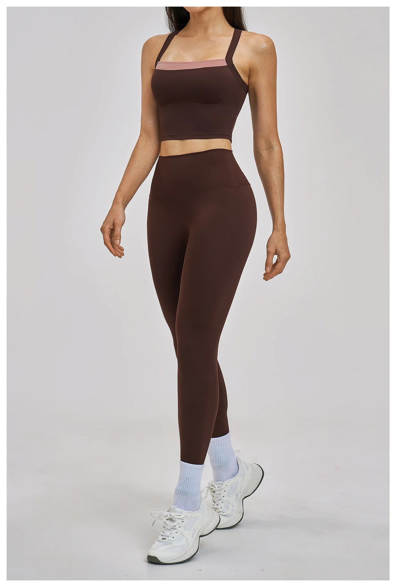 Person wearing a brown sports bra and leggings set on a gray background