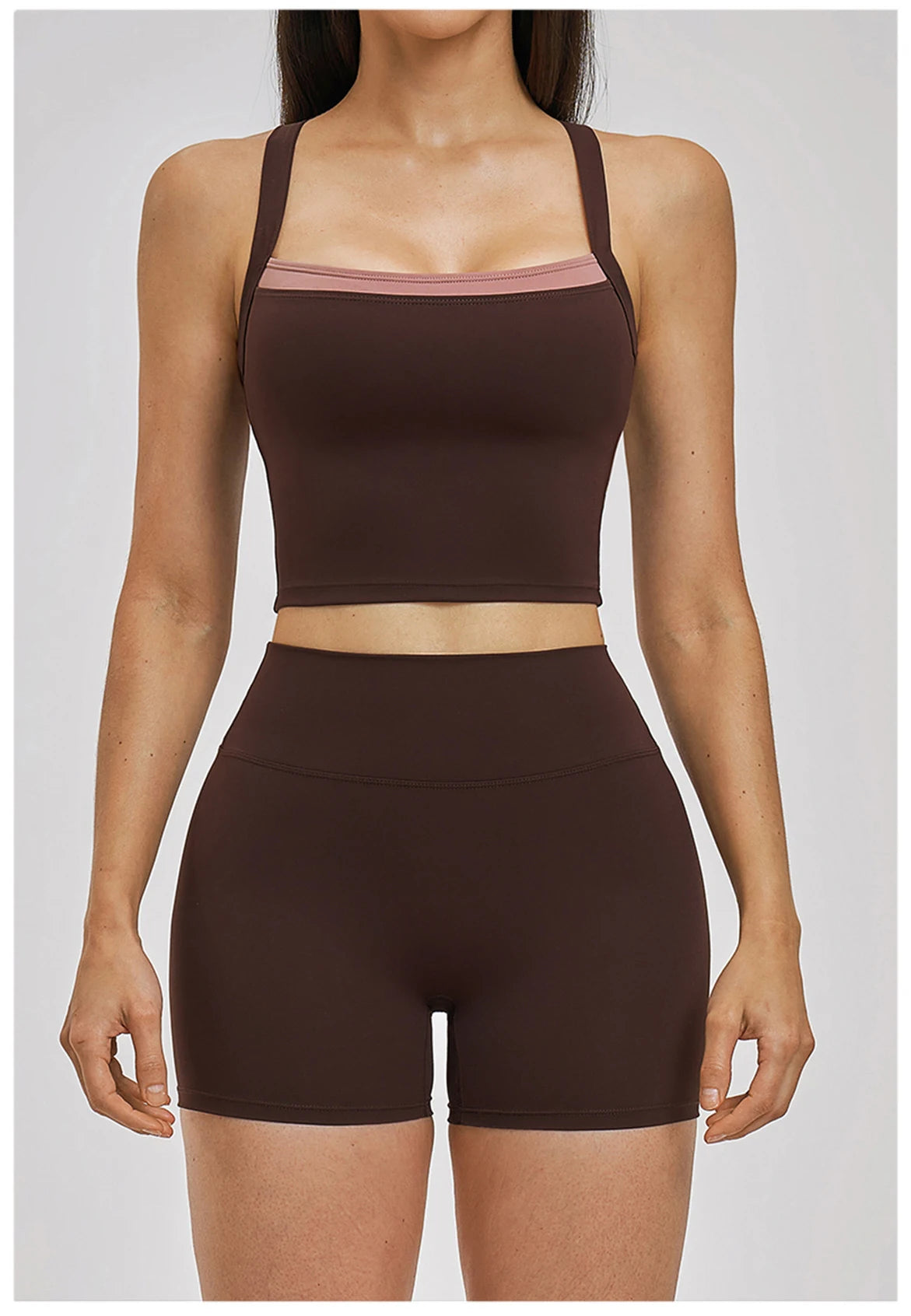 Woman wearing a brown sports bra and shorts set on a white background