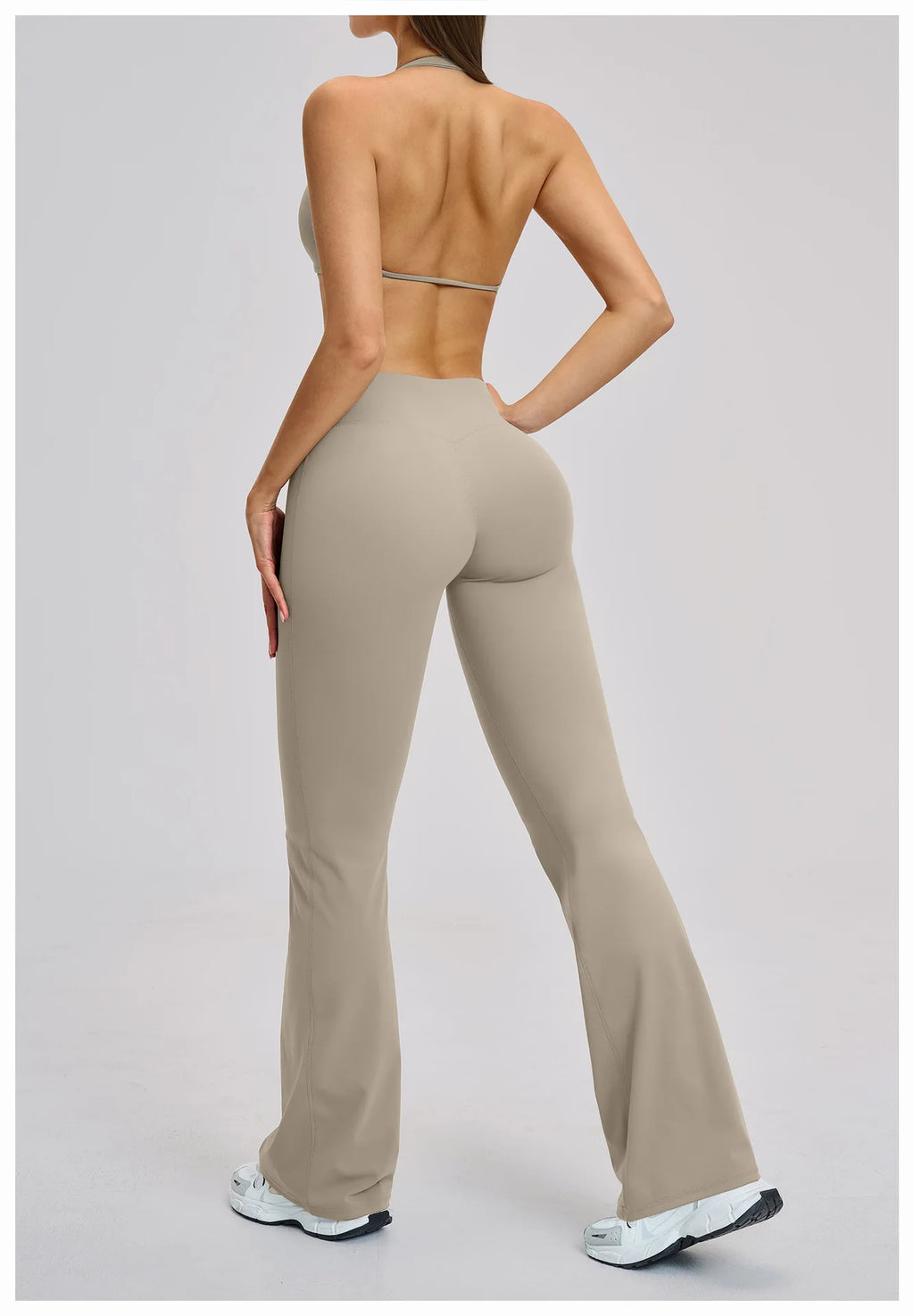 Person wearing beige high-waisted pants on a plain background