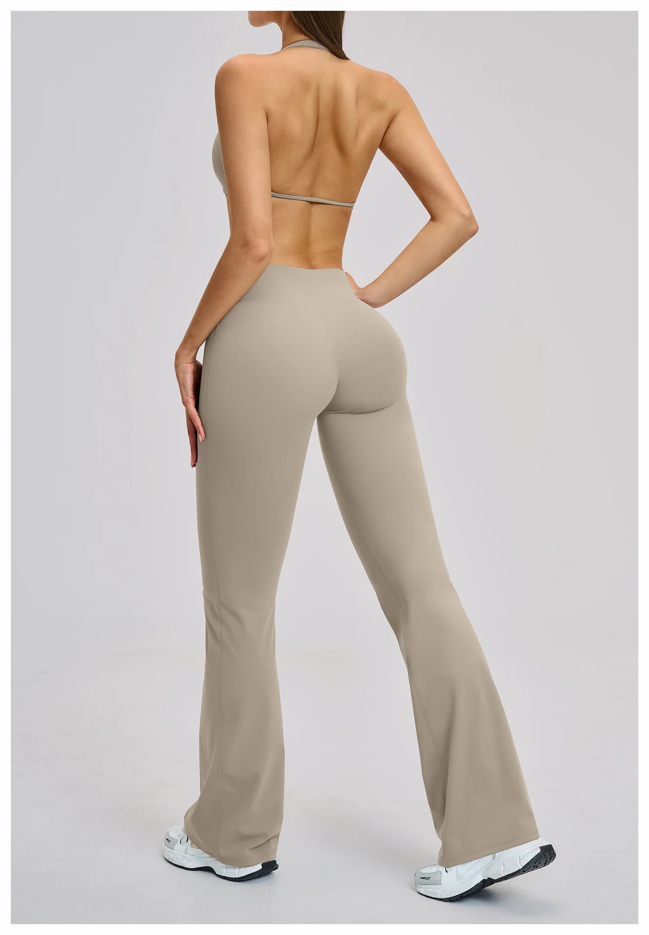 Person wearing beige high-waisted pants on a plain background
