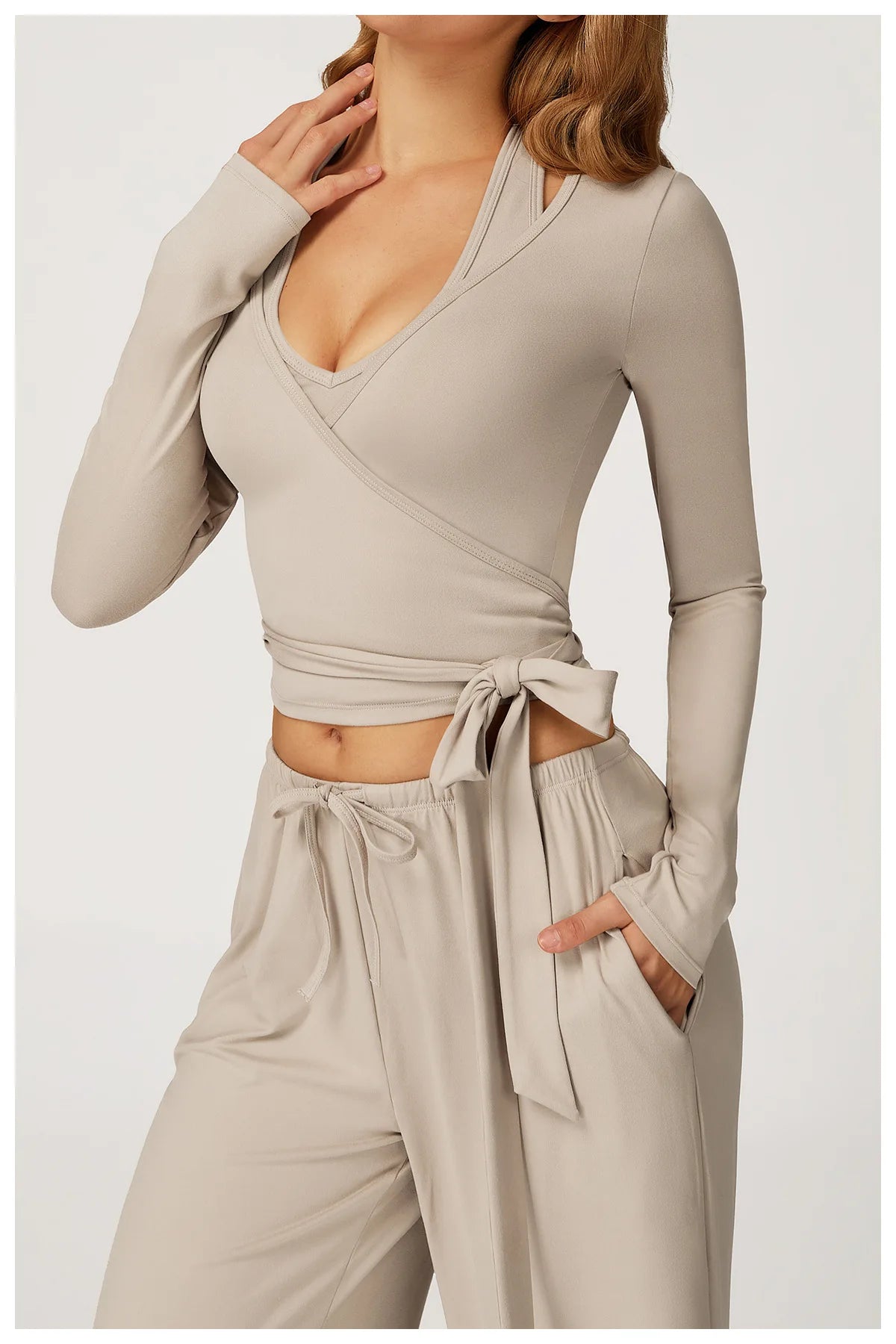 Beige long-sleeve ballet wrap top and pants set on a white background