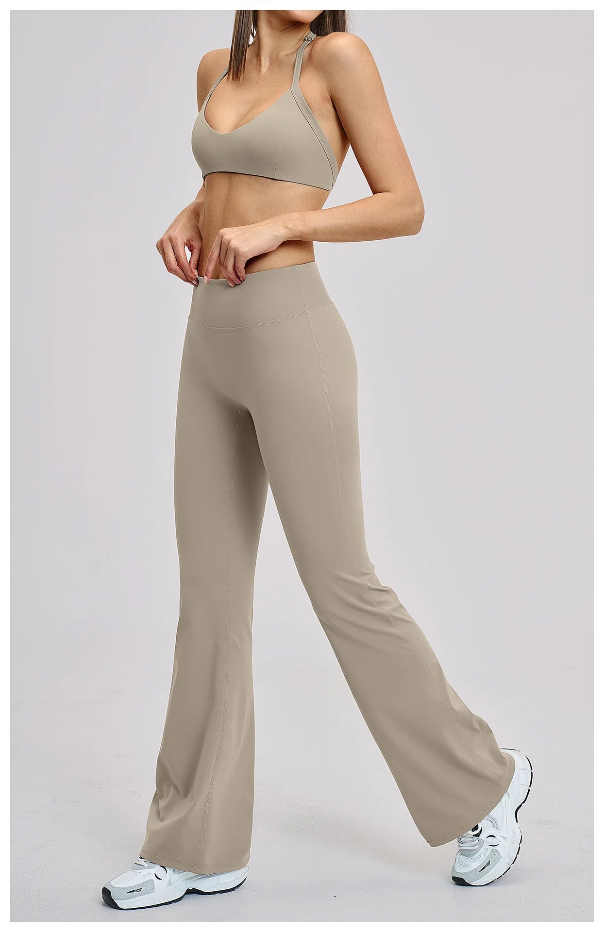 Person wearing a beige sports bra and leggings set on a light gray background