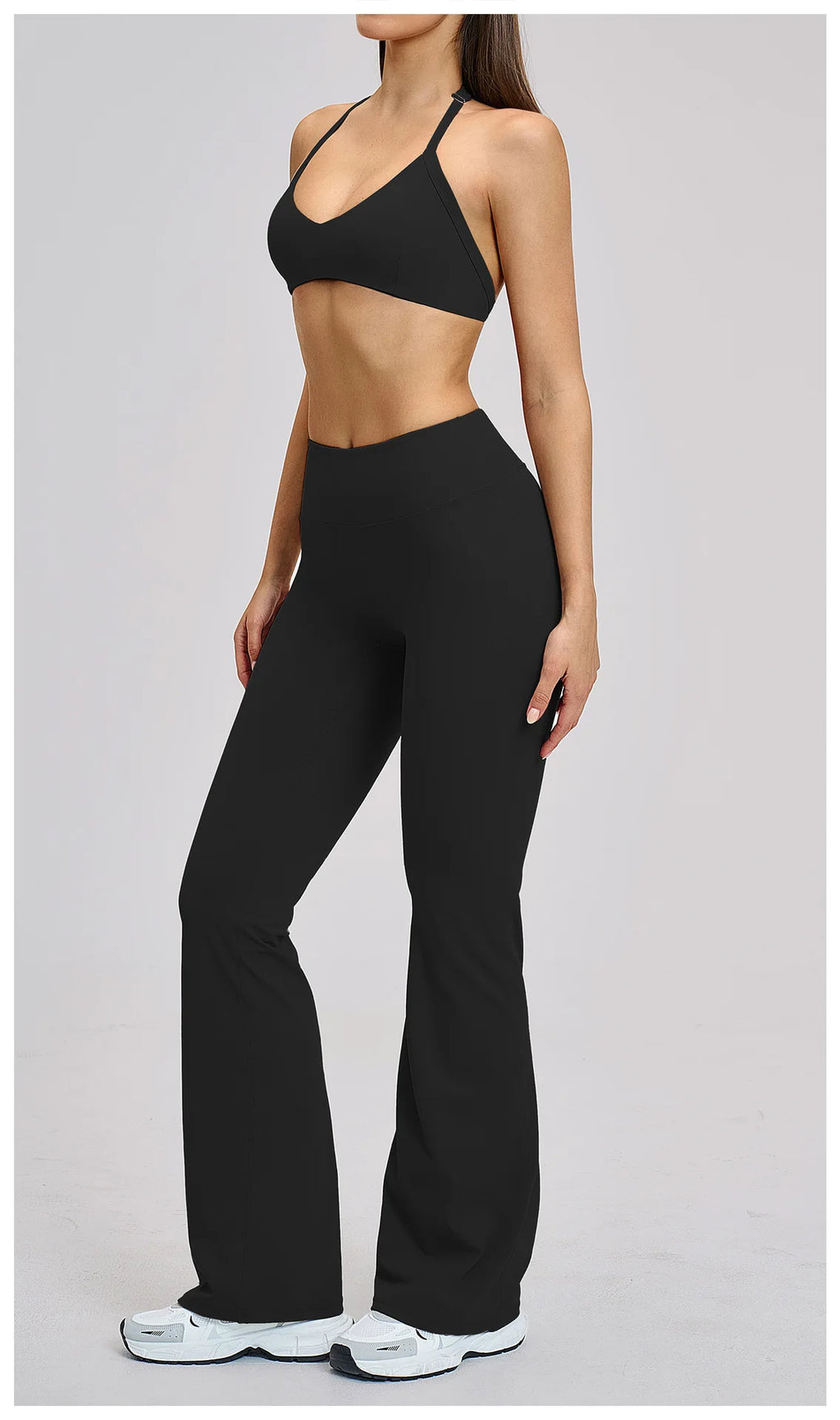 Person wearing a black sports bra and leggings on a gray background