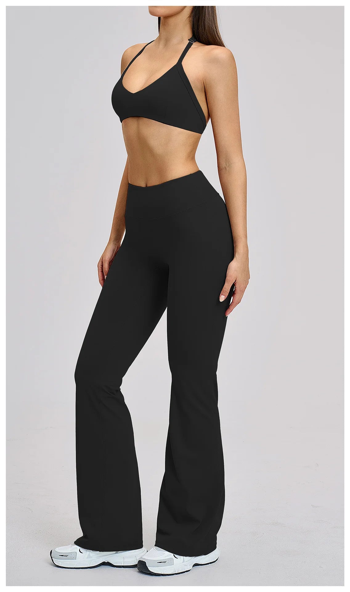 Person wearing a black sports bra and leggings on a gray background