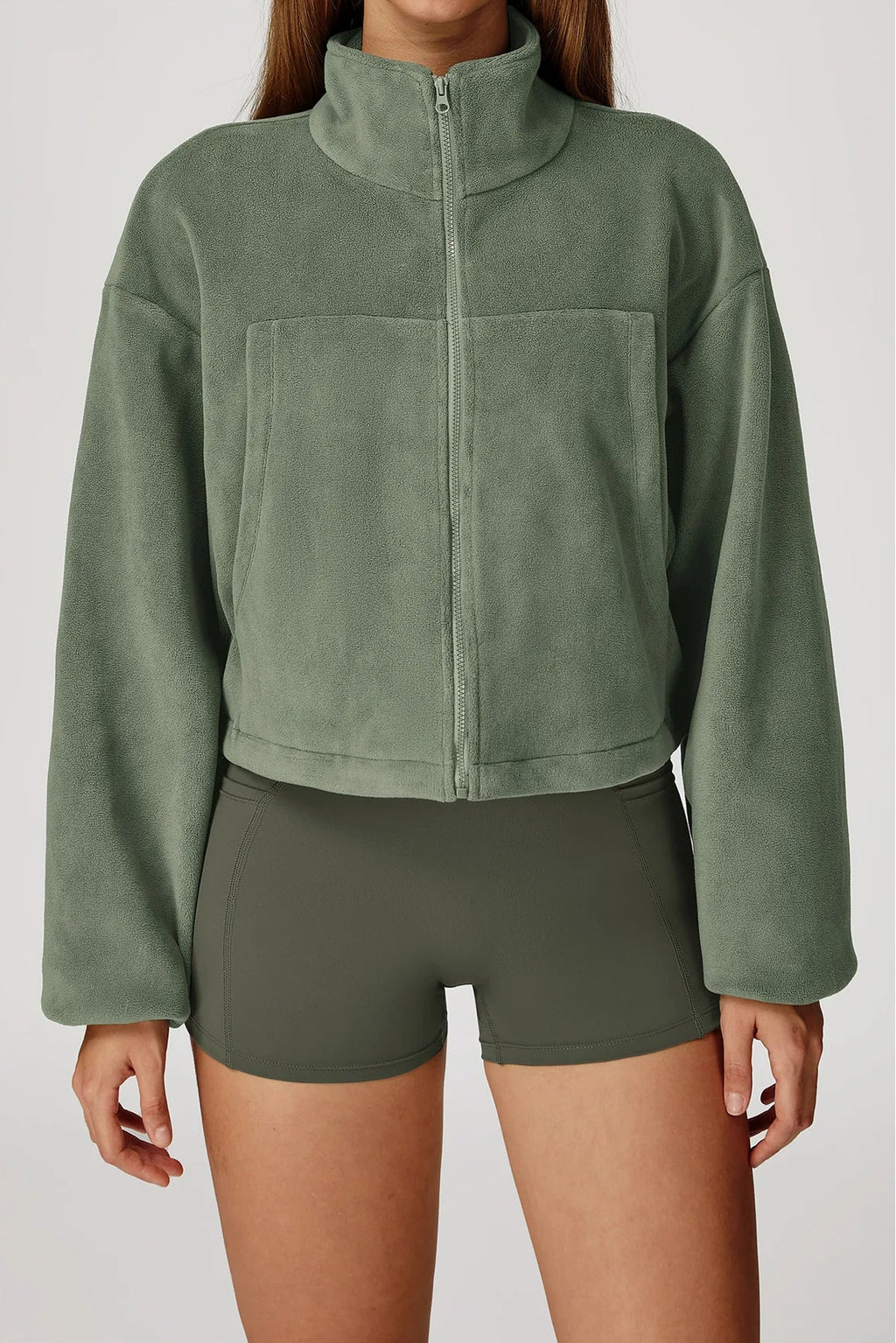 Green fleece jacket and shorts on a plain background