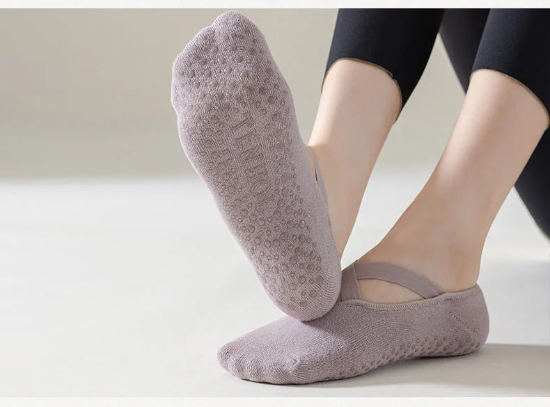 Purple socks with textured sole worn by a person on a light background