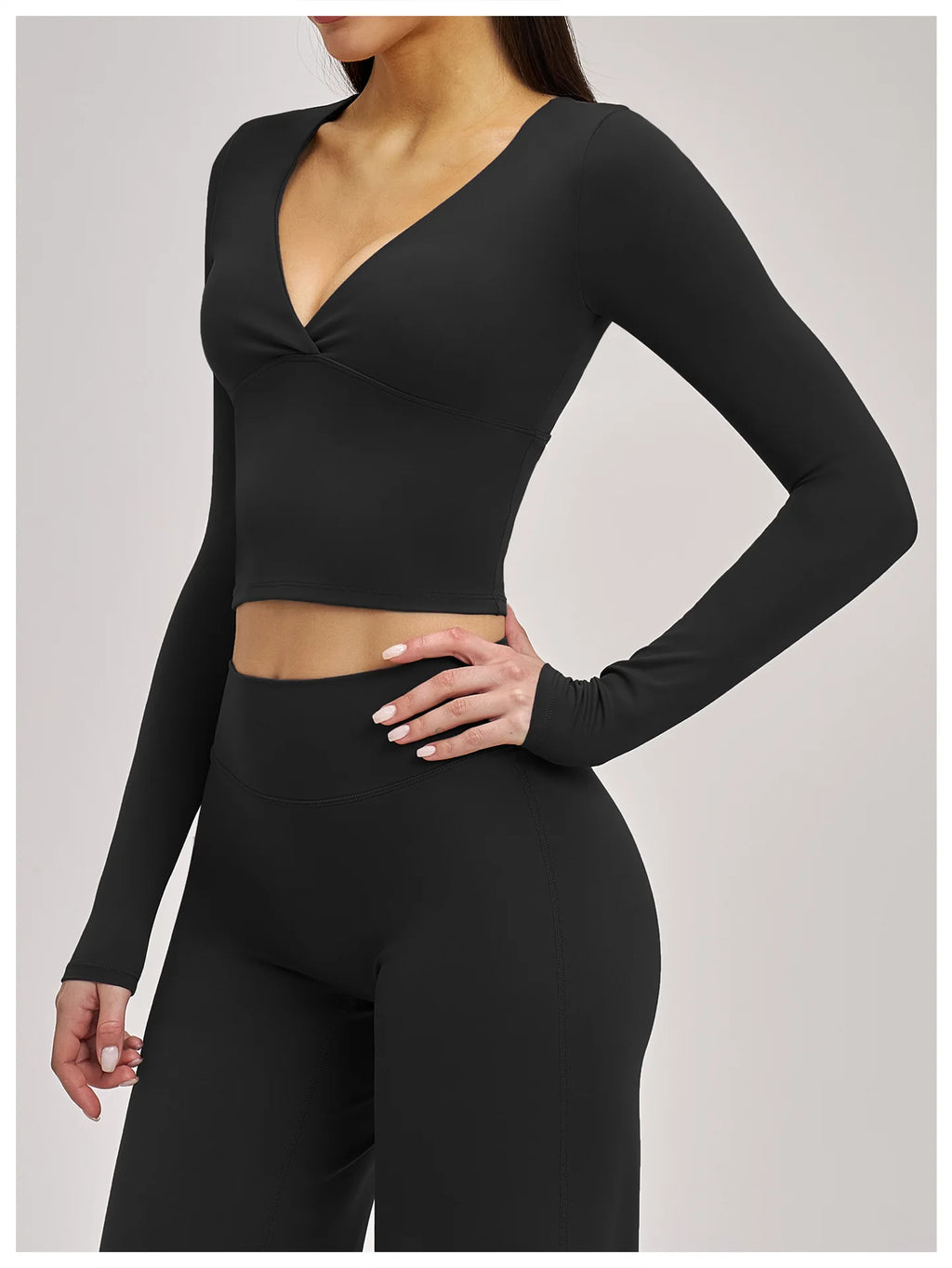Black long-sleeve crop top and leggings set on a plain background
