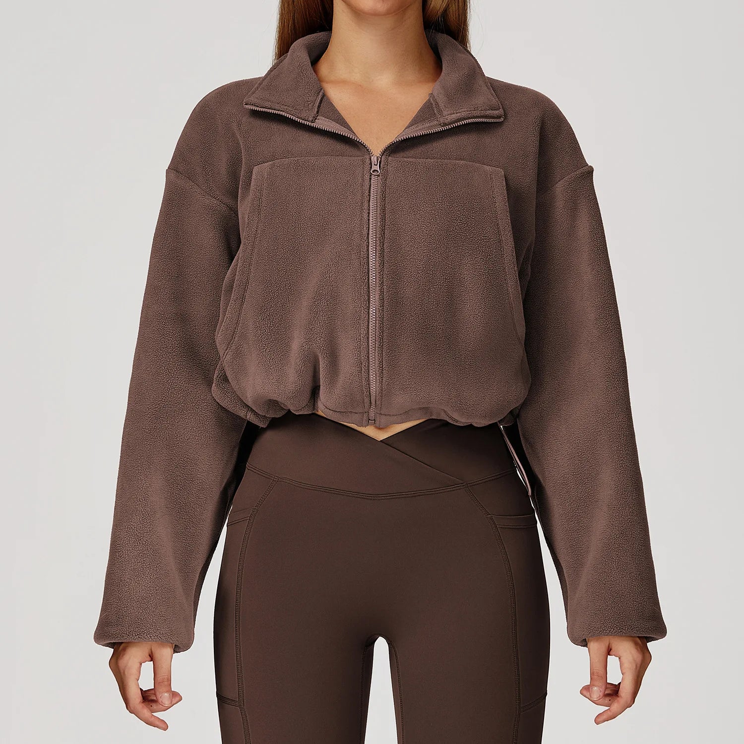 Brown fleece jacket and leggings on a plain background