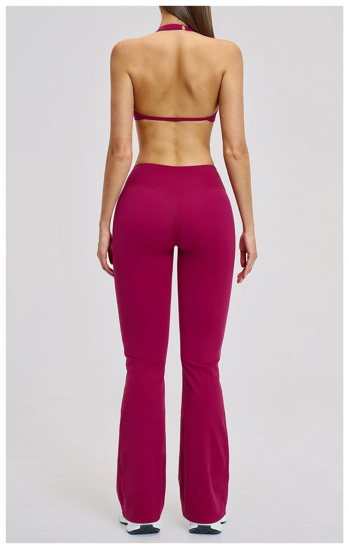 Person wearing a magenta sports bra and leggings on a white background