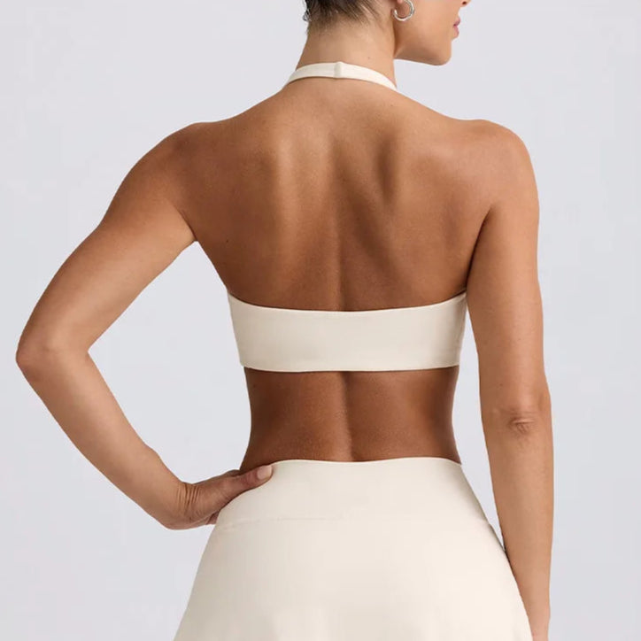 Woman wearing a white halter top and skirt set on a light gray background