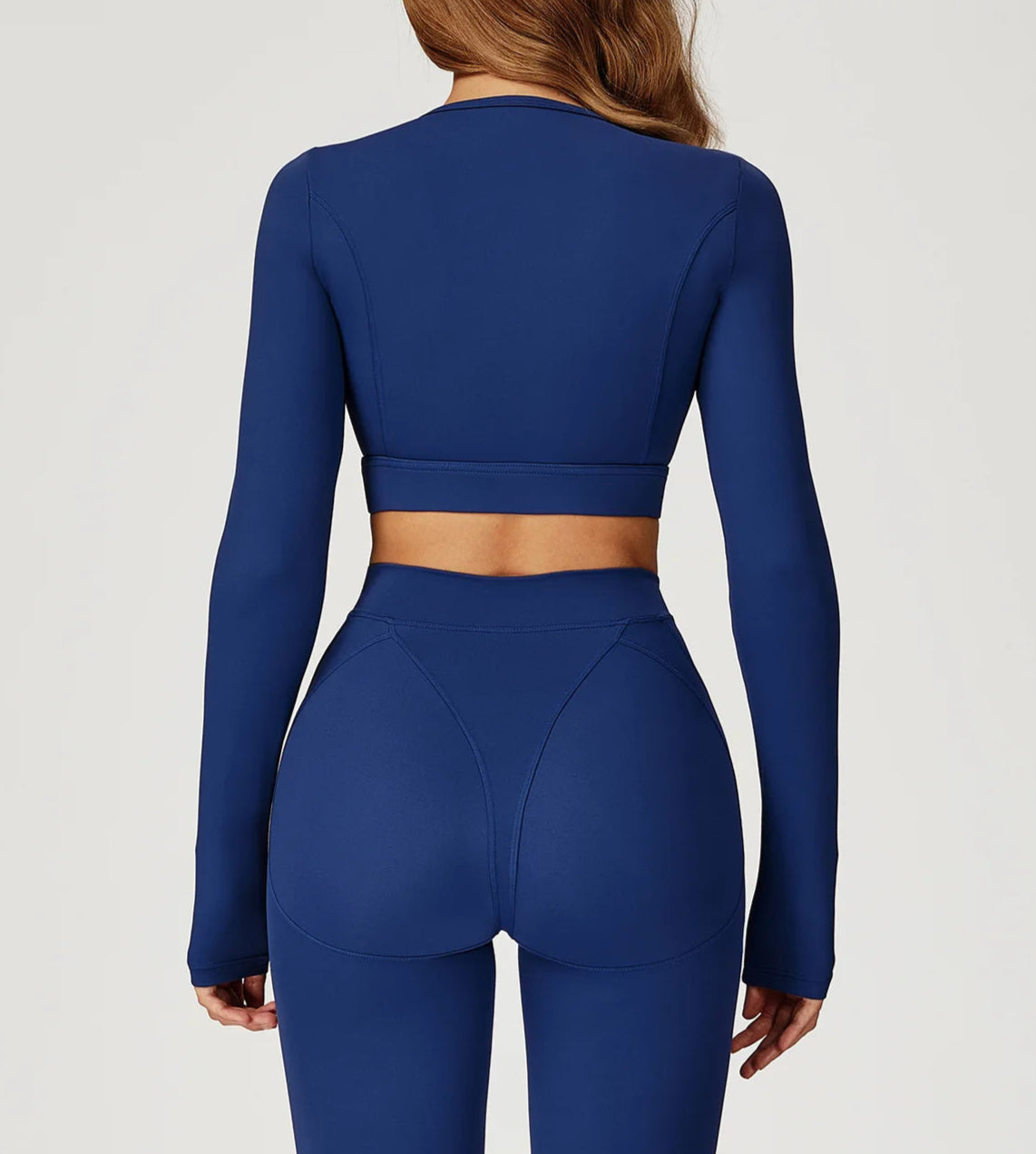 Blue athletic outfit with long-sleeve top and leggings on a plain background