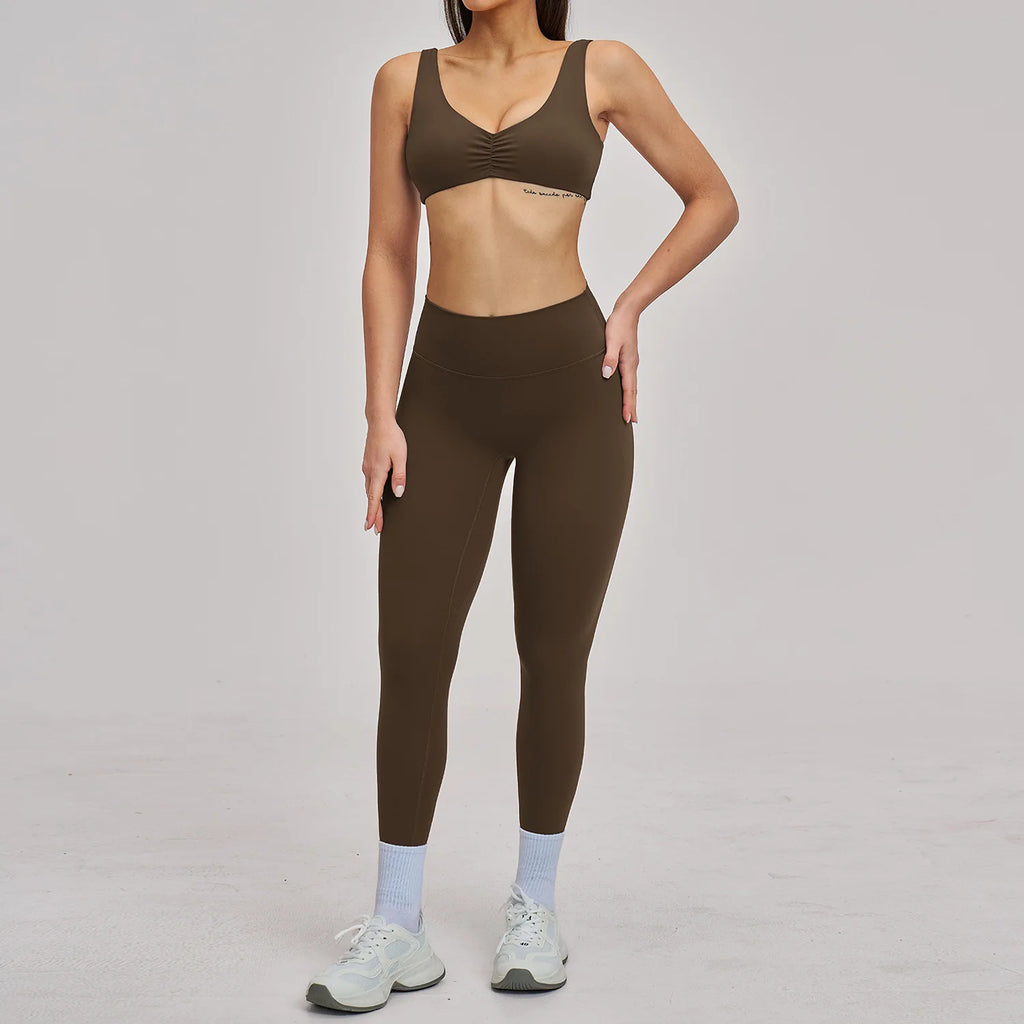 Person wearing a brown sports bra and leggings set on a gray background