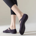 Person wearing dark purple non-slip socks on a light background