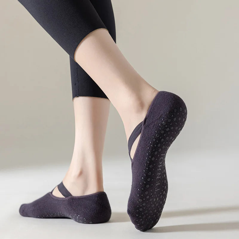 Person wearing dark purple non-slip socks on a light background