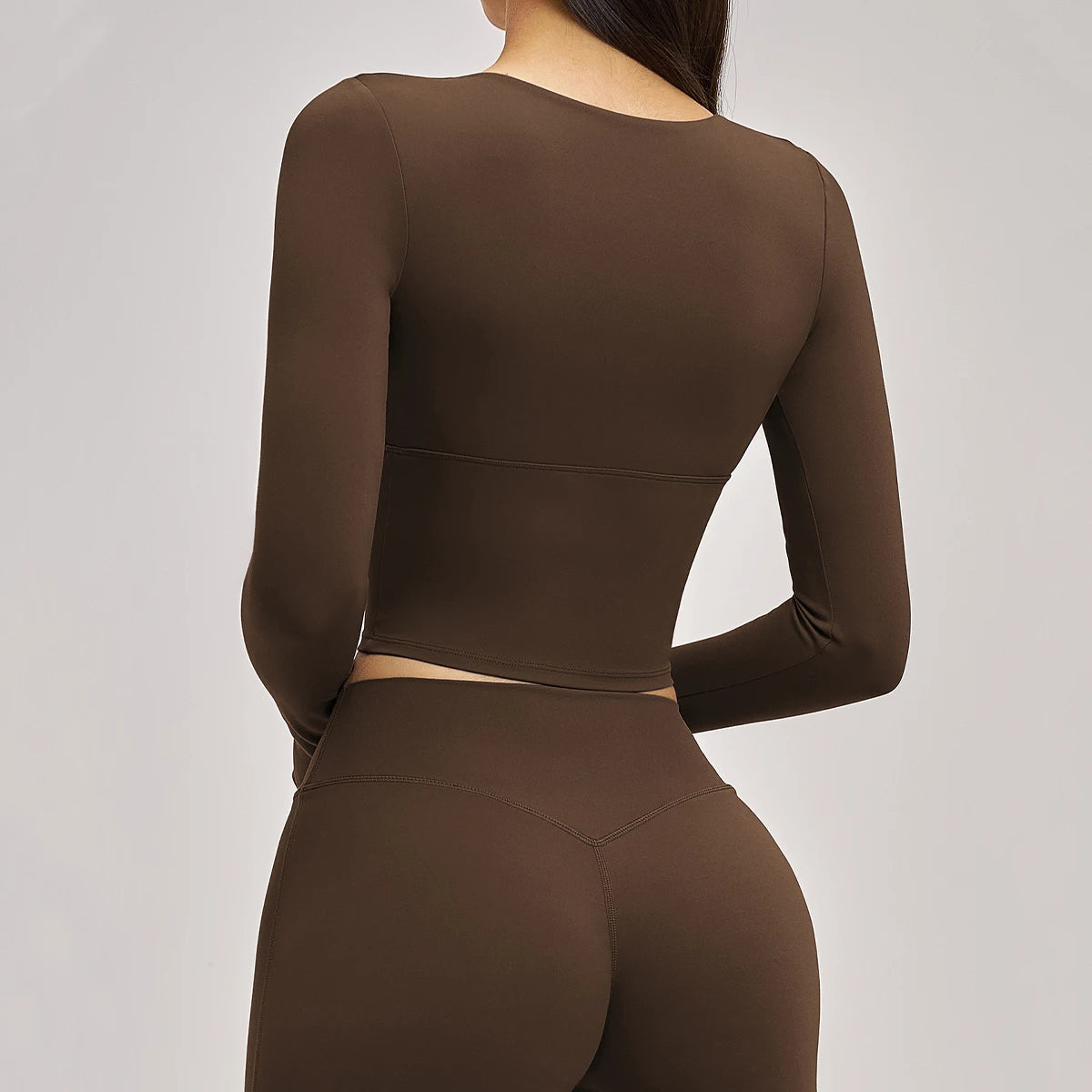 Brown long-sleeve top and leggings set on a plain background