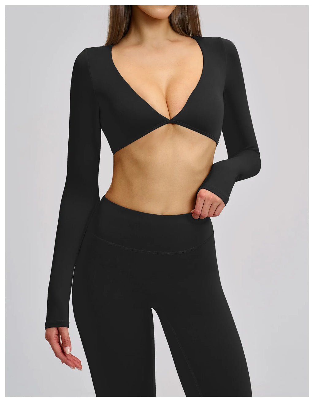 Black long-sleeve crop top and leggings on a plain background