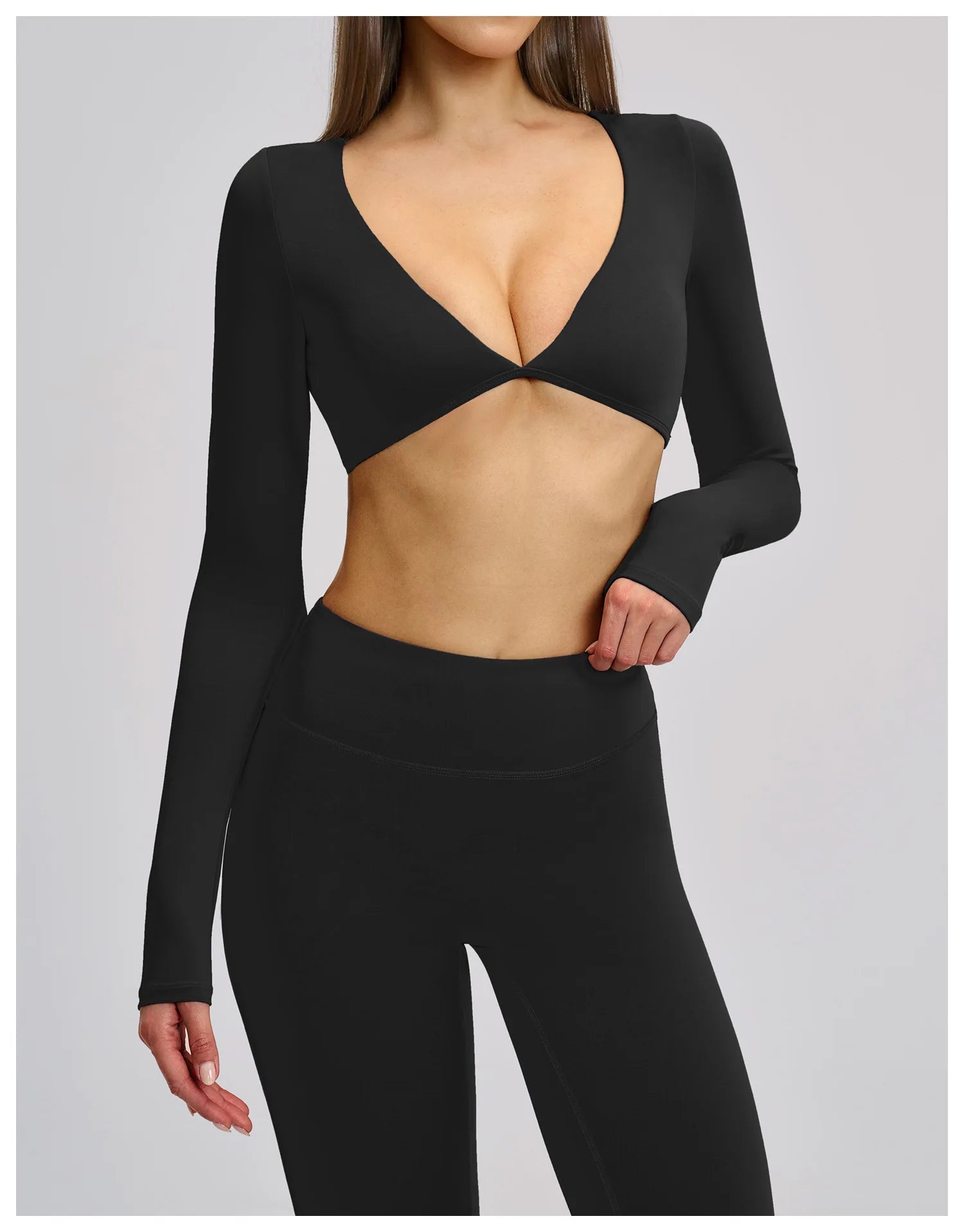 Black long-sleeve crop top and leggings on a plain background