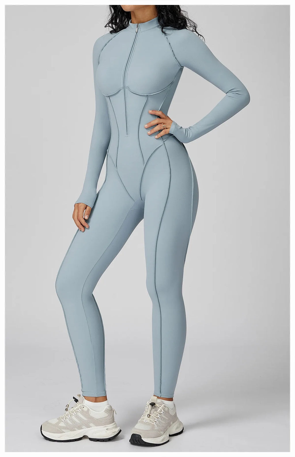 Person wearing a light blue full-body suit on a gray background