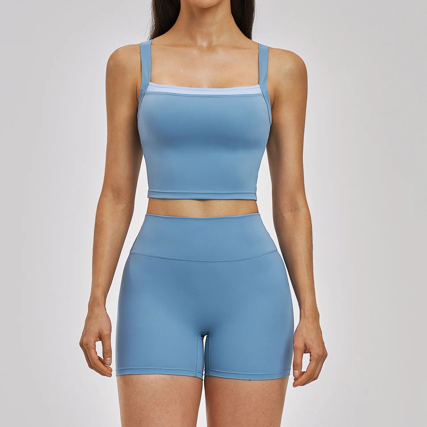 Woman wearing a blue athletic outfit on a plain background