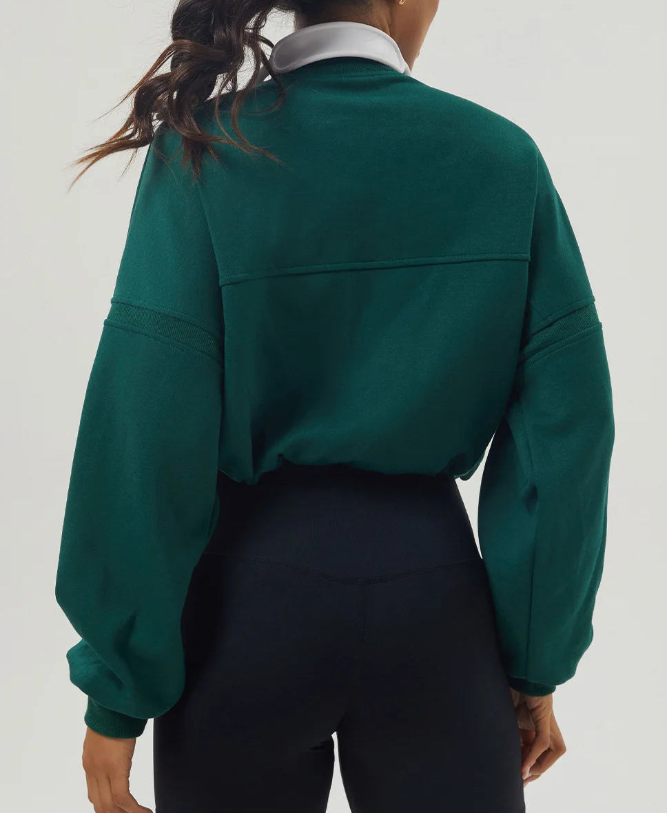 Person wearing a green jacket on a plain background.

