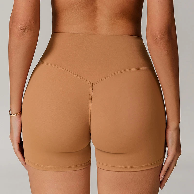 Brown athletic shorts worn by a person on a neutral background