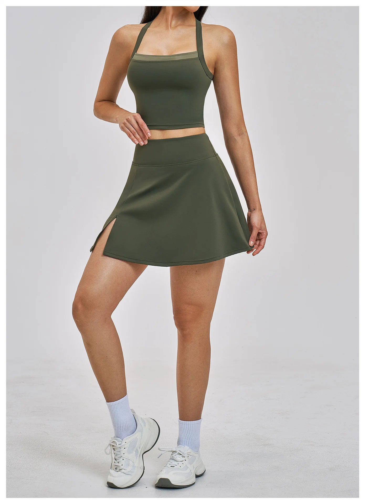 Person wearing a green athletic outfit with a skirt on a light gray background