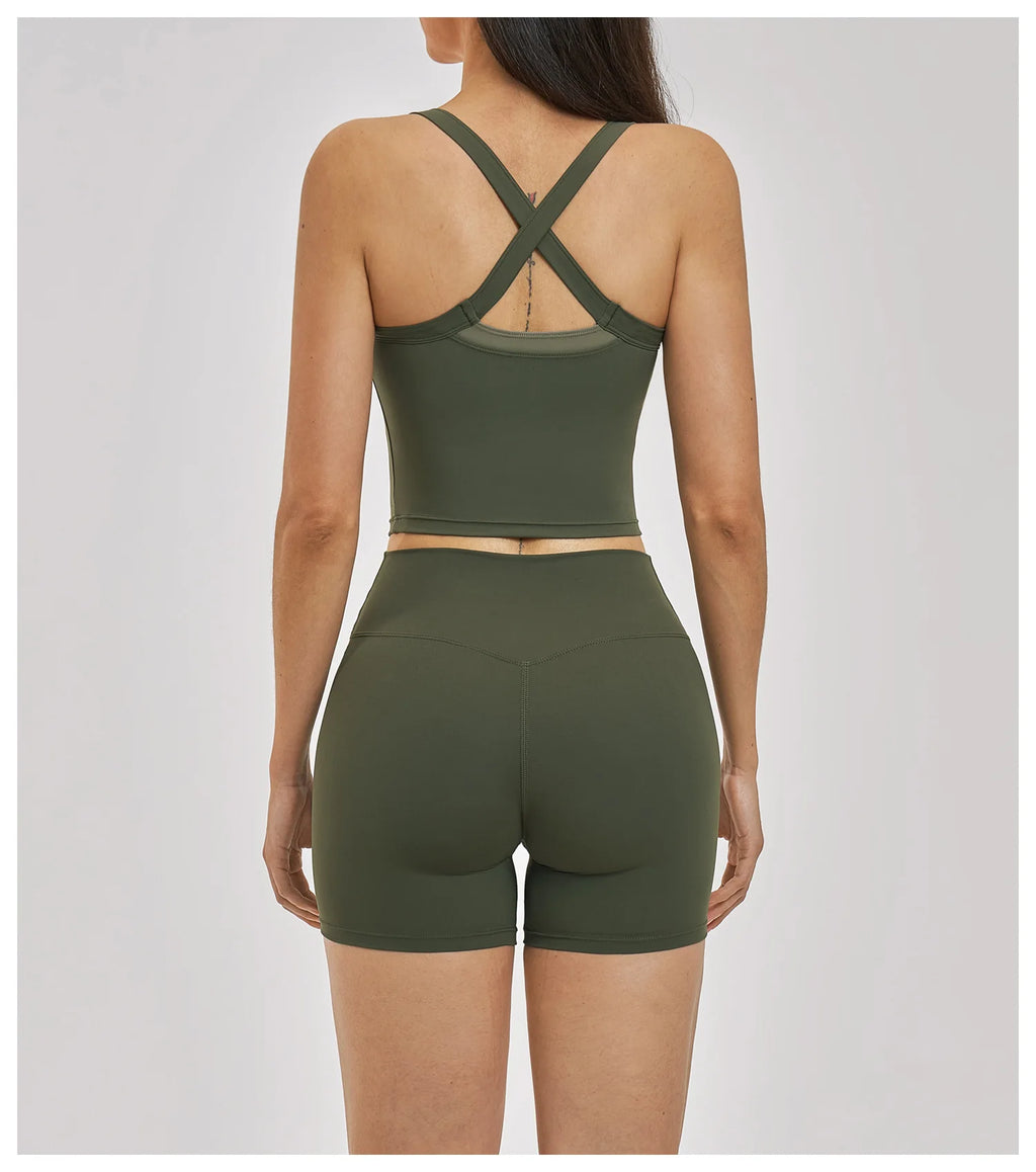 Person wearing a green sports bra and shorts set on a light gray background