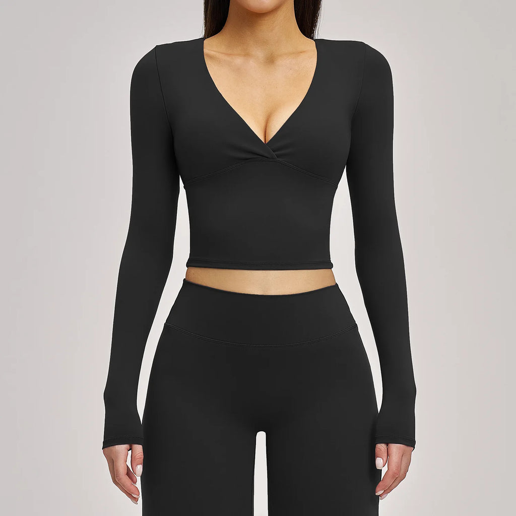 Black long-sleeve crop top and leggings set on a gray background