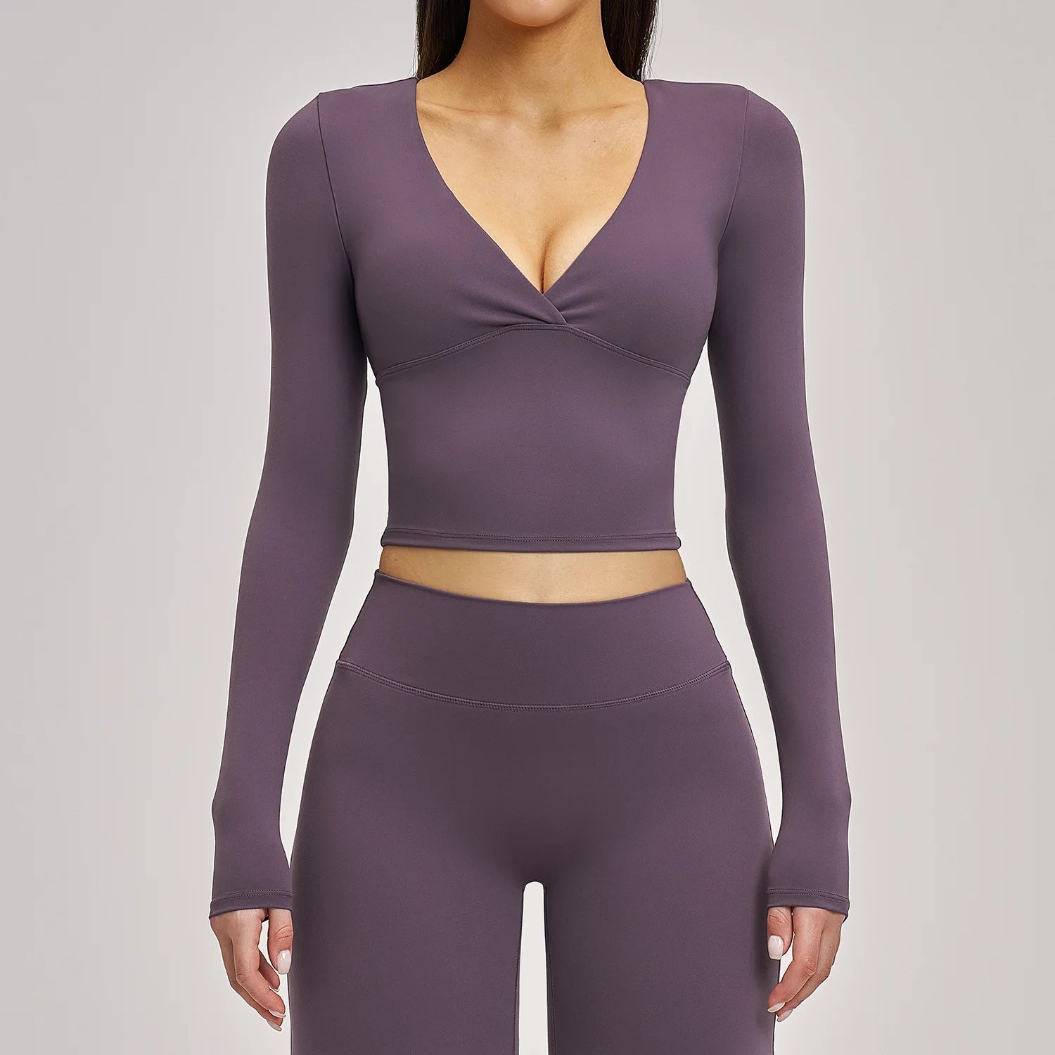 Purple long-sleeve athletic top and leggings set on a gray background