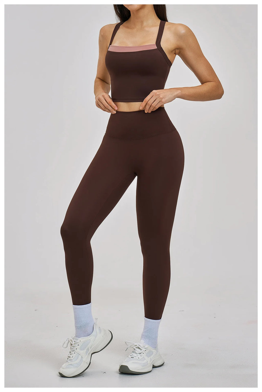 Person wearing a brown sports bra and leggings set on a white background