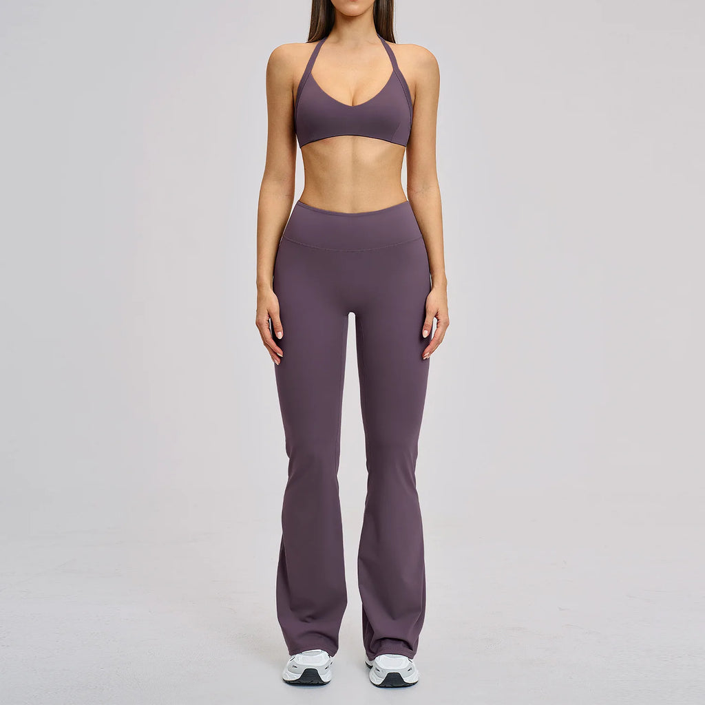 Person wearing a purple sports bra and leggings set on a gray background