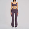 Person wearing a purple sports bra and leggings set on a gray background